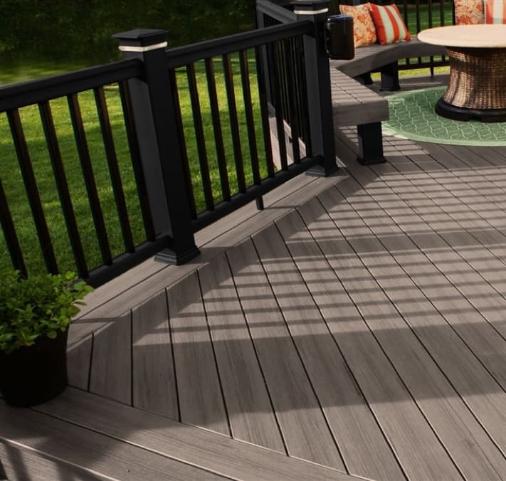 Grey decking with railing and patio furniture.