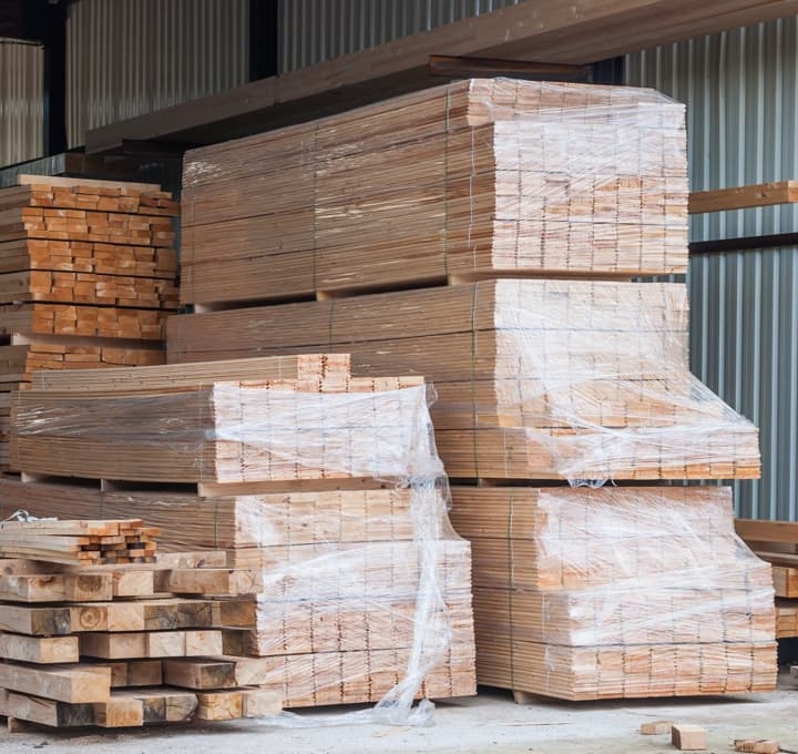 Bundles of lumber and boards in warehouse.